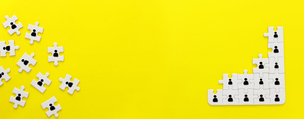 ild von Puzzleteilen mit Menschen Icons über gelben Hintergrund, Humanressourcen soziale Distanzierung und Management Konzept
