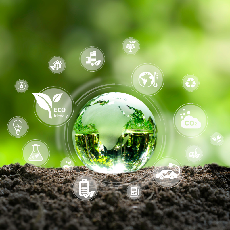 Gläserner Globus auf Erdboden, umringt von Icons zu Energie, CO₂, Recycling und Nachhaltigkeit.