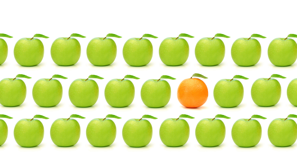 Reihen grüner Äpfel mit einer einzelnen Orange in der Mitte als Sinnbild für eine unverwechselbare Marke.